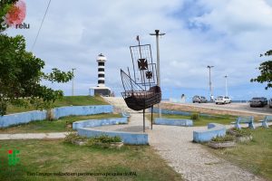 Foto do Farol visto de longe, mostrando uma praça