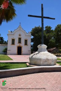 Foto da Igreja São José do Poxim vista de frente, de longe, mostrando uma cruz na frente dela
