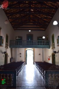 Foto da igreja vista de dentro, mostrando os bancos