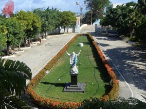 Seminário Arquidiocesano visto de frente, mostrando uma estátua de costas em um jardim