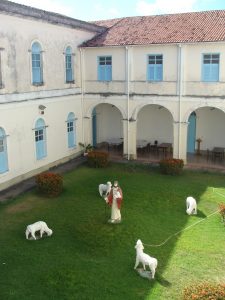 Seminário Arquidiocesano visto de dentro, mostrando uma estátua de Jesus com quatro cordeiros ao redor